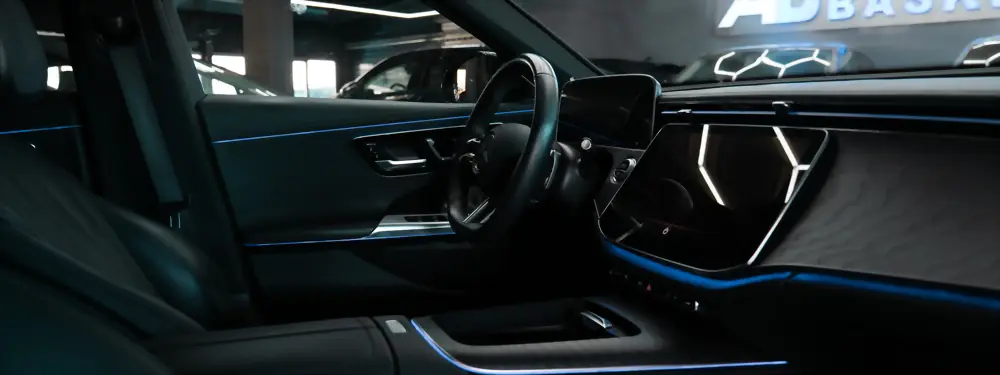Cockpit eines Mercedes mit Breitbildschirm und blauer Ambientebeleuchtung