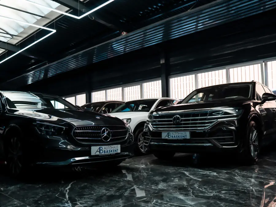 Mercedes E-Klasse und VW Touareg mit Baskent-Kennzeichenhaltern in der Halle