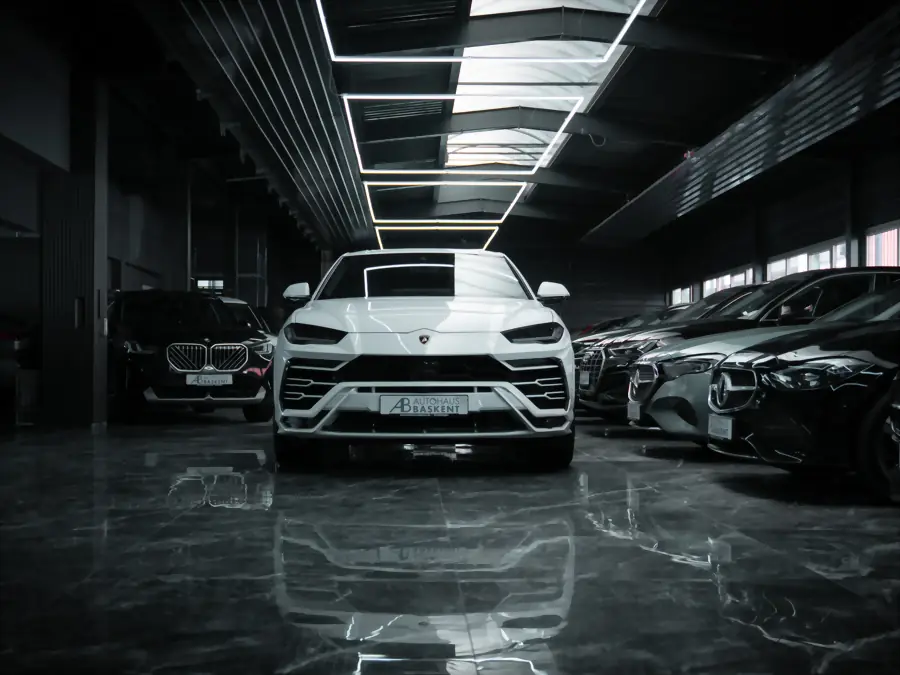 Weißer Lamborghini Urus frontal unter der Hexagon-Beleuchtung